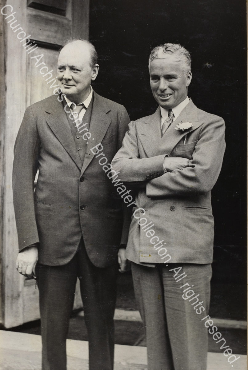 Photo shows WSC and Charlie Chaplain standing outside a doorway.