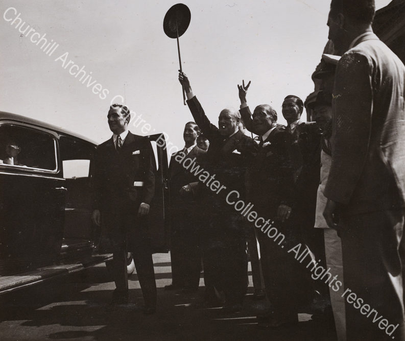 Photo shows WSC jubilantly holding his hat on top of his walking cane