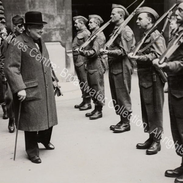 WSC inspects the Palace of Westminster Home Guard in Speaker's Court. Photo shows WSC wearing an overcoat and hat