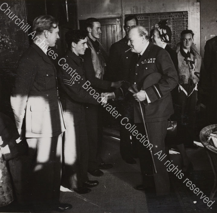 Photo shows WSC shaking hands with a sergeant pilot of 615 Fighter Squadron during a visit to RAF Manston