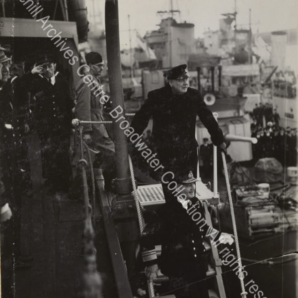 Photo shows WSC about to walking down the steps to leave a ship [?the Duke of York]. Admiral Sir Dudley Pound