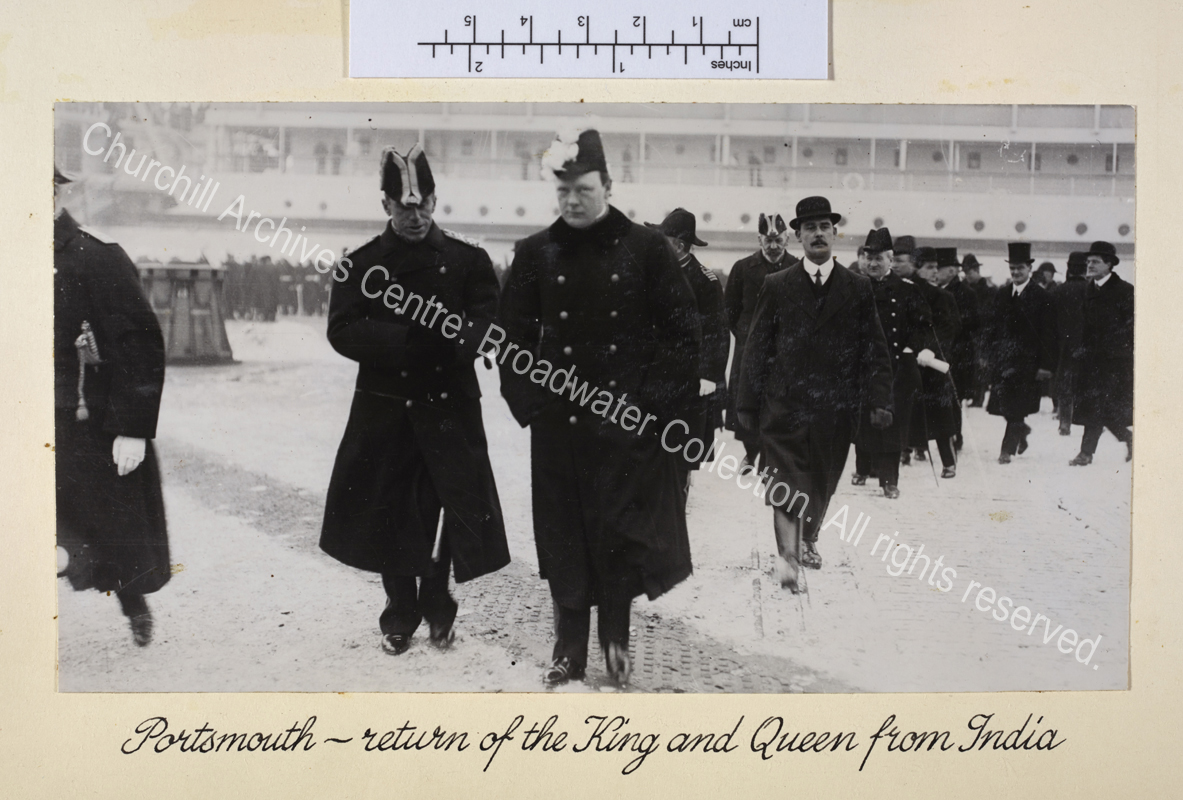 WSC wearing Privy Councillor's uniform and peaked feathered hat is shown walking towards the camera among a line of people. In the background there is a large ship.