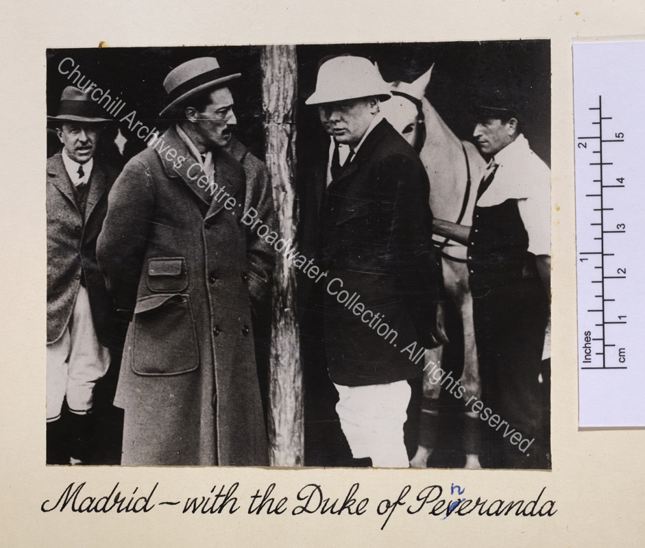 Photo shows WSC wearing riding clothes and hat talking to the Duke. Behind WSC there is a grey horse.