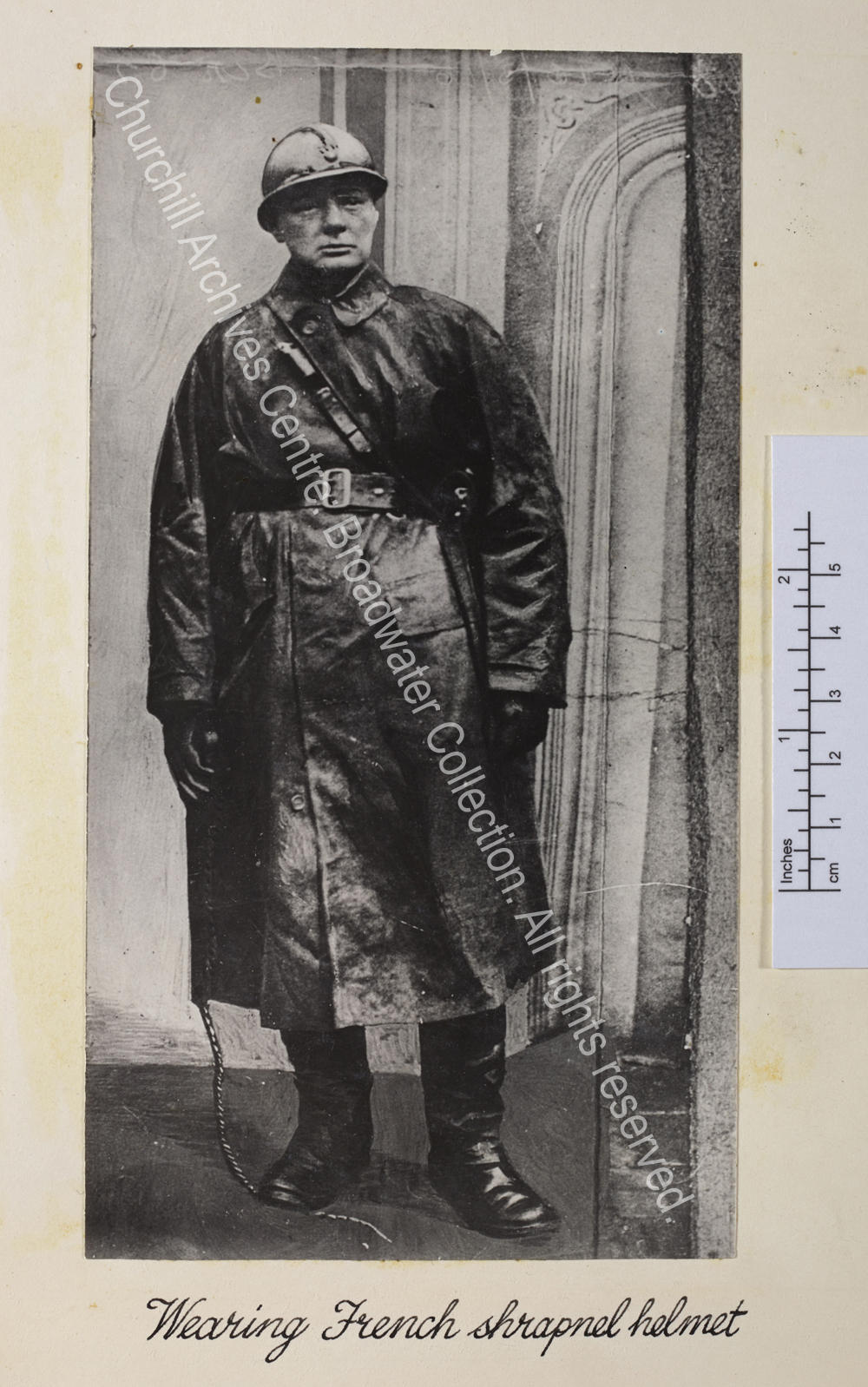 Photo shows WSC wearing a mackintosh and Sam Browne belt and metal helmet.