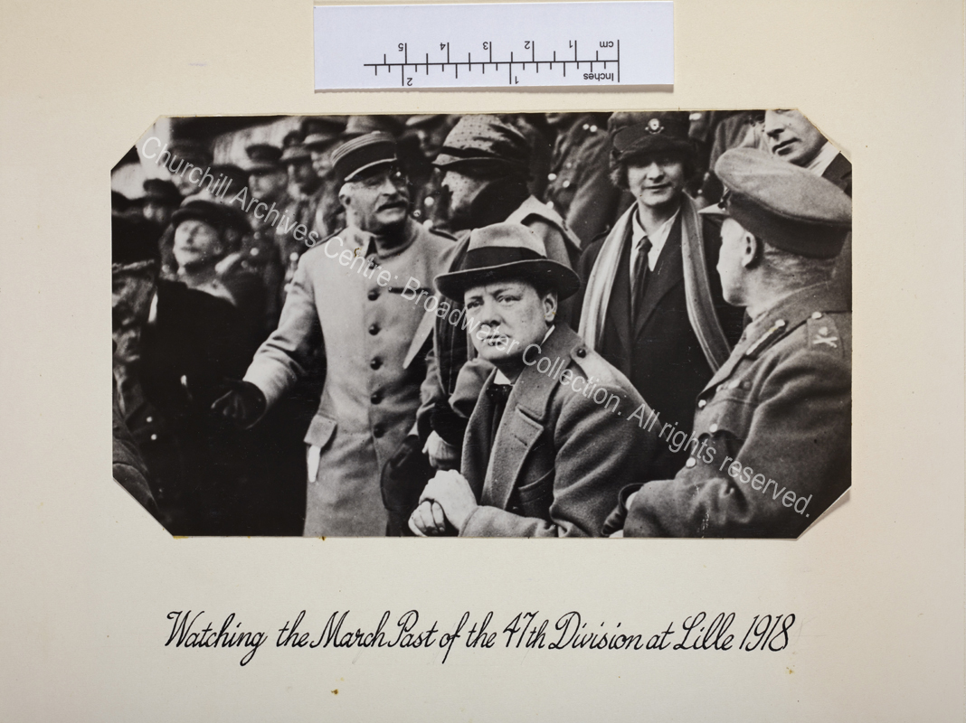 WSC seated in a crowd leaning on a walking stick.