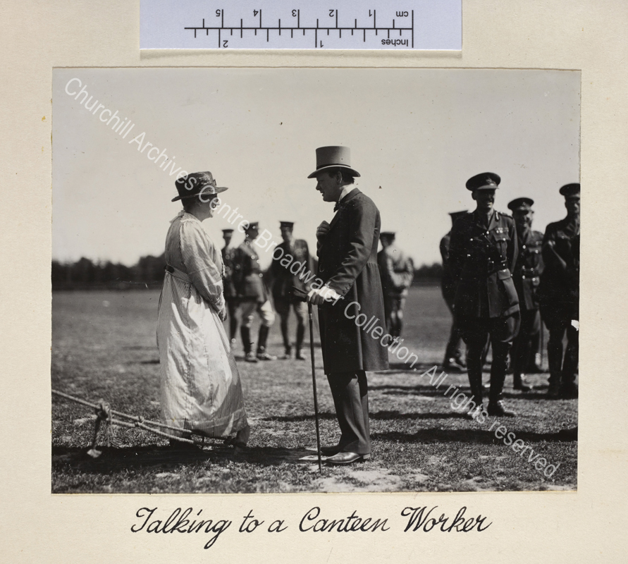 Photo shows WSC talking to a woman wearing a straw hat and a long cotton dress during visit to inspect British forces in Cologne