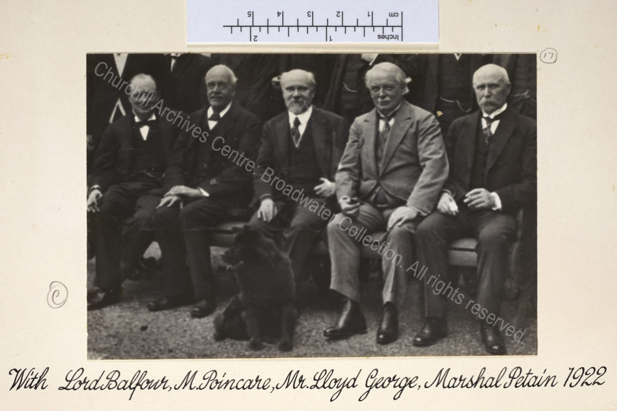 Photo shows the group of men seated in a line with WSC to the left and a black dog in the foreground.