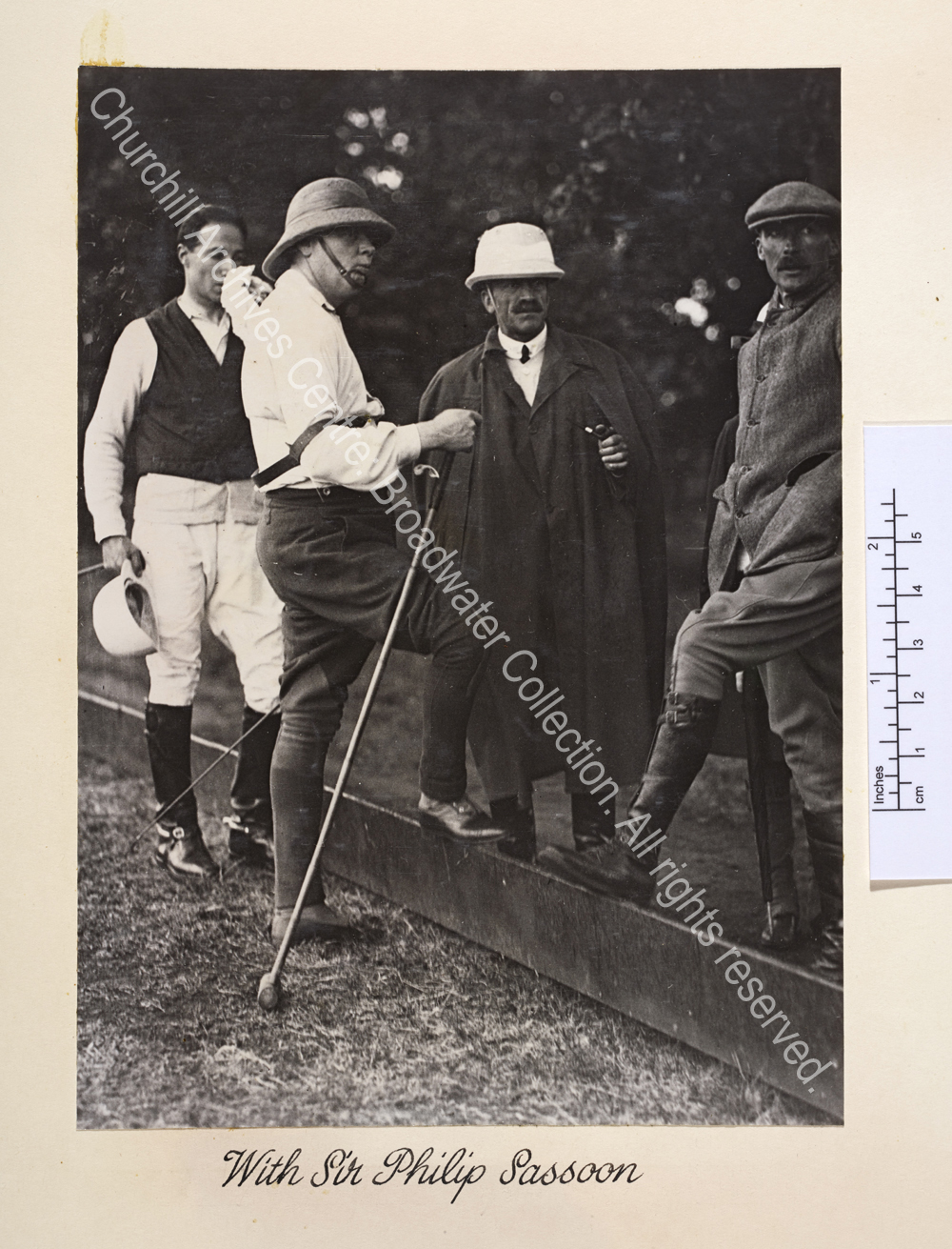 Photo shows WSC wearing riding breeches and hat and leaning on a polo mallet