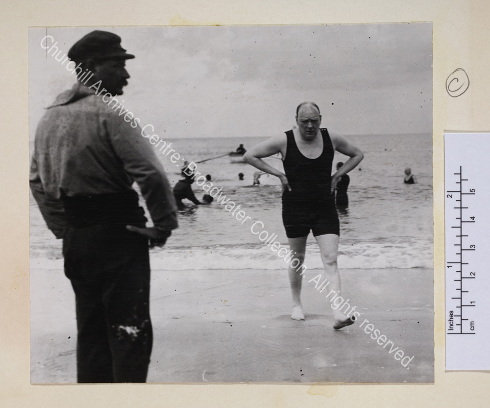 Photo of WSC striding out of the sea wearing a bathing suit.