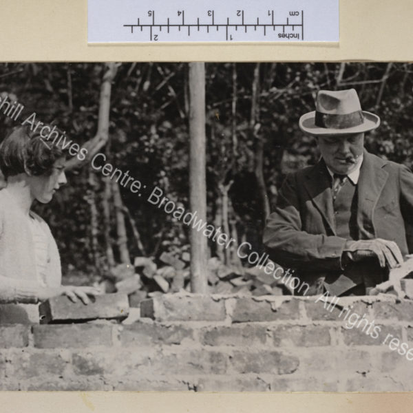 Photo of WSC (cigar in mouth) bricklaying at Chartwell with Sarah [Churchill