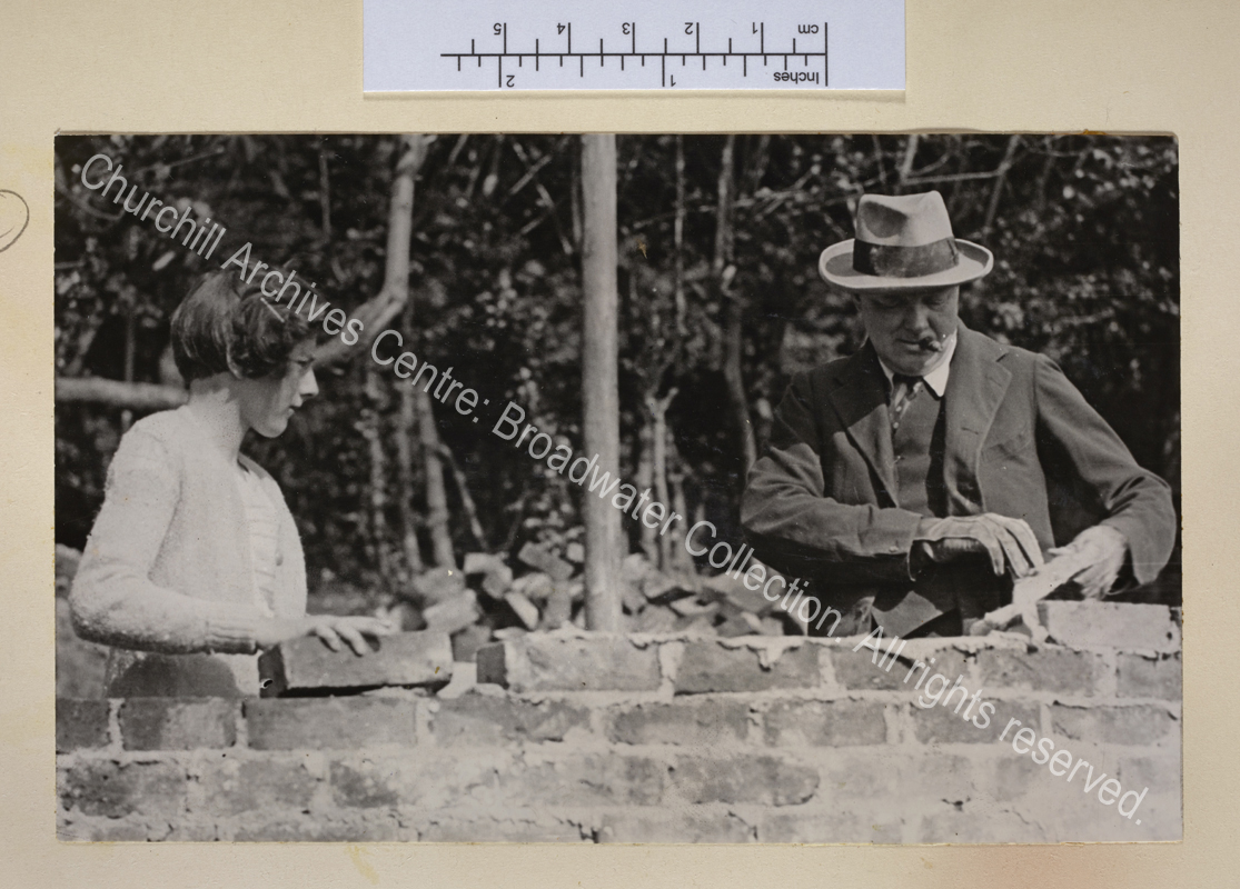 Photo of WSC (cigar in mouth) bricklaying at Chartwell with Sarah [Churchill