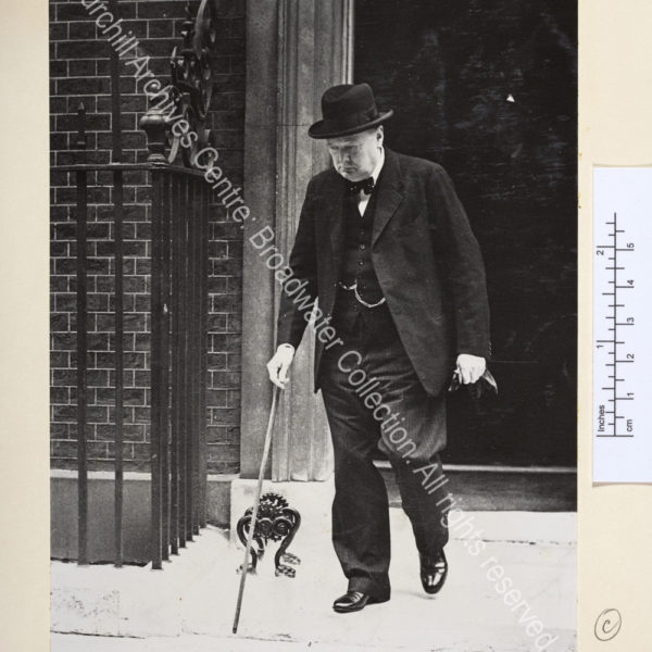WSC leaving a building with his eyes downcast and wearing a serious expression.