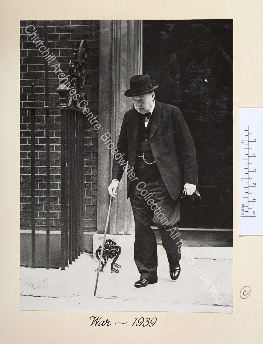 WSC leaving a building with his eyes downcast and wearing a serious expression.