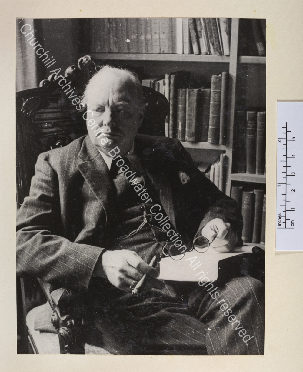 Photo shows WSC seated with a book on his lap
