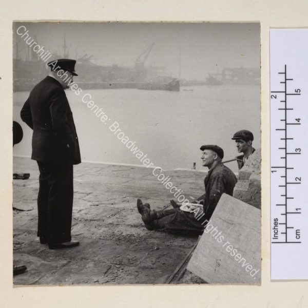 Photo shows WSC standing at the docks [in Liverpool] talking to two working men