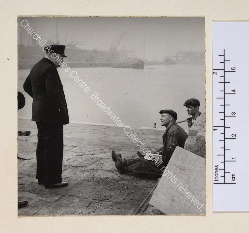Photo shows WSC standing at the docks [in Liverpool] talking to two working men