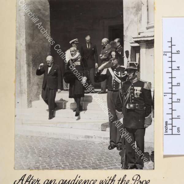 Photo shows WSC walking down exterior steps [?at the Vatican] with a uniformed Vatican official and soldiers.