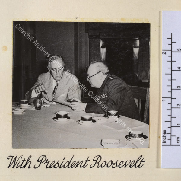 Photo shows WSC and President Roosevelt deep in conversation [at the Yalta conference]. They are sitting at a table on which there are empty coffee cups.