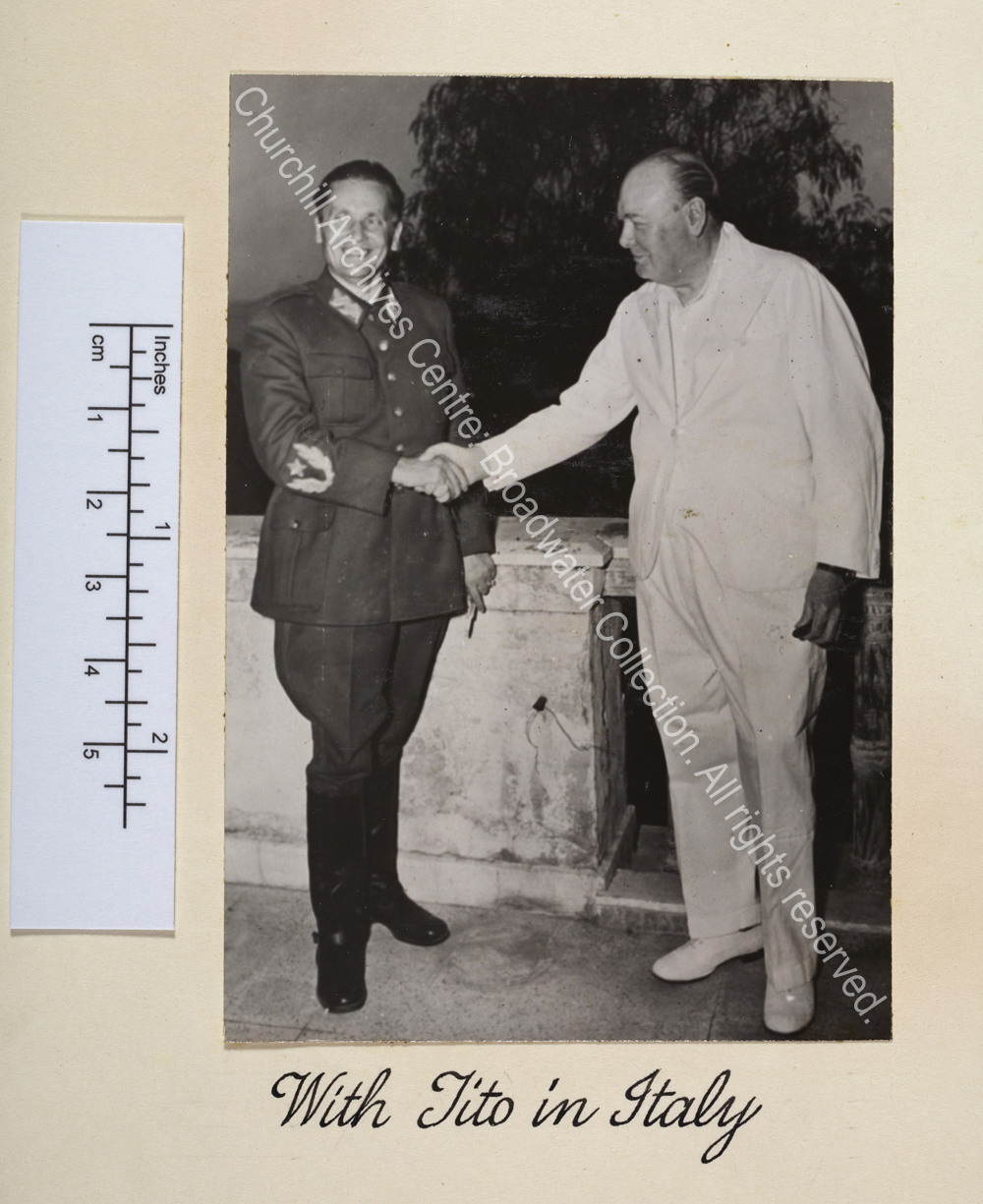 Photo shows WSC wearing a white suit shaking hand with Marshal Tito