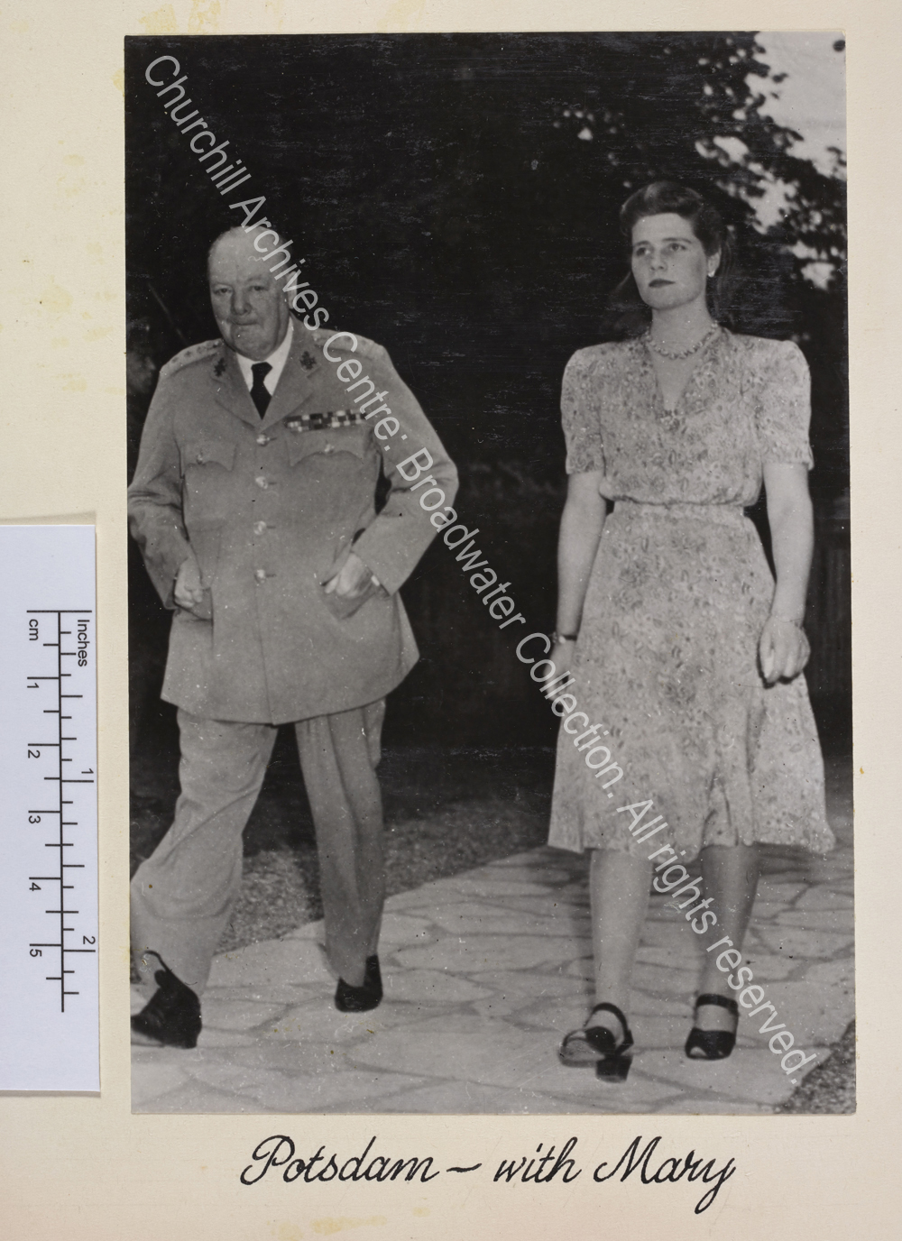 Photo shows WSC and Mary Churchill [later Mary Soames] walking towards the camera. WSC is in uniform and Mary wears a light summer dress.