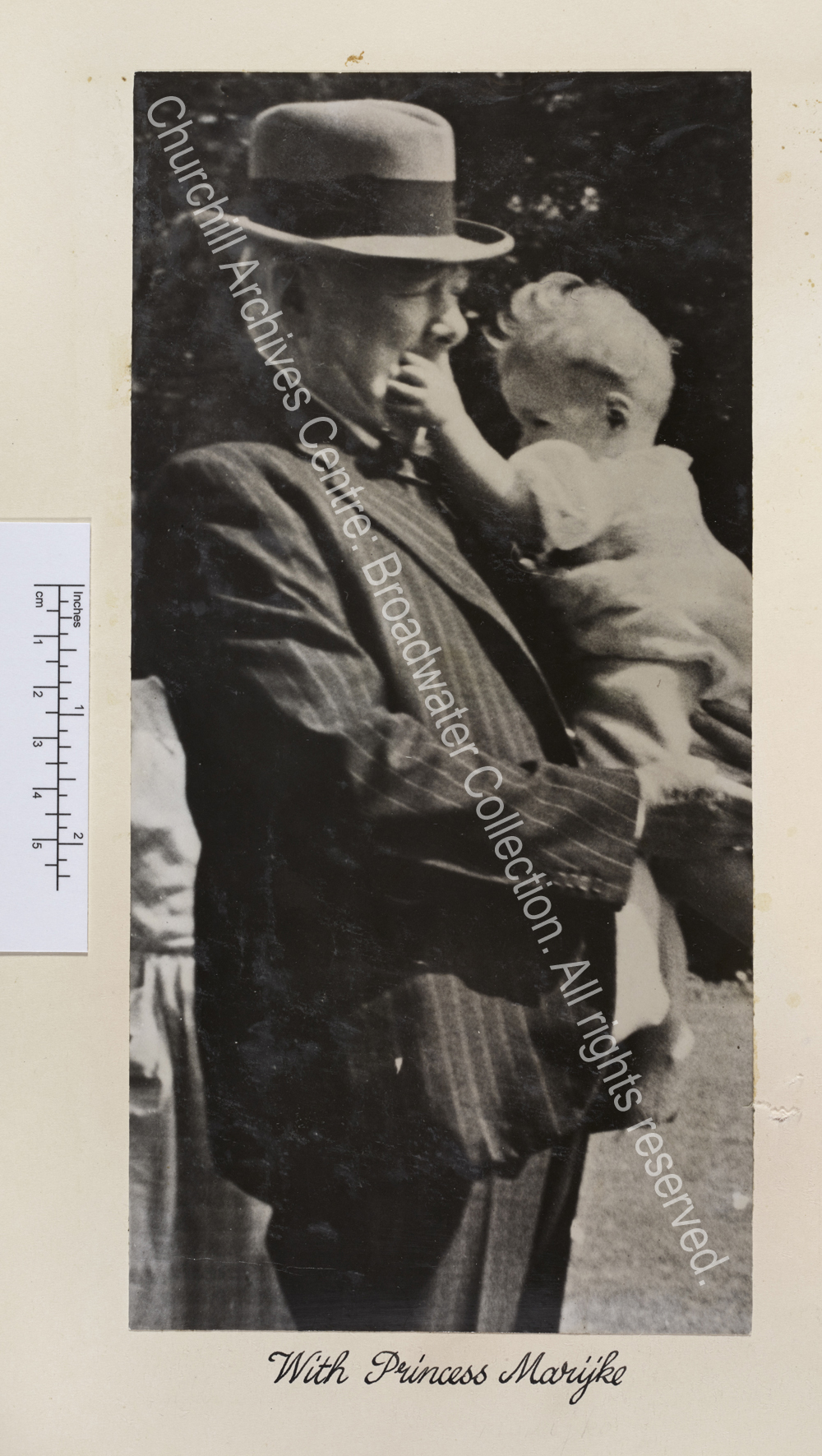 Photo shows WSC holding a baby in his arms. The baby is putting her hand in his mouth.