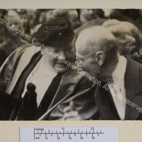 Photo shows WSC wearing a cap and leaning towards King Haakon.