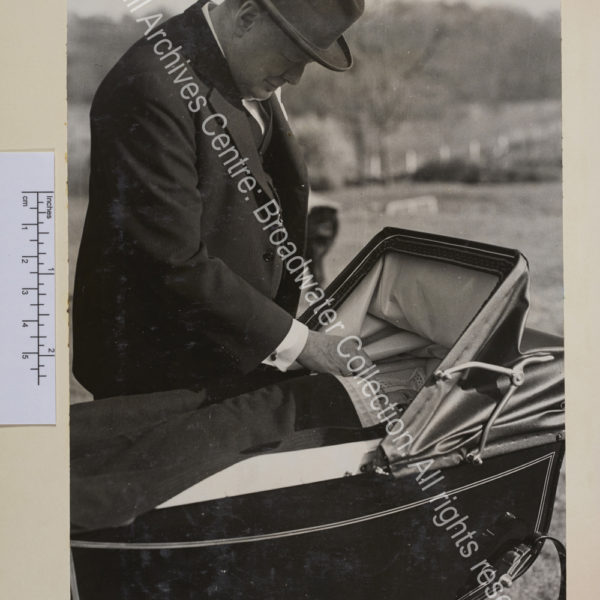 Photo shows WSC smiling at Nicholas [Soames] who is a baby in a pram. WSC reaches in to stroke Nicholas' cheek.