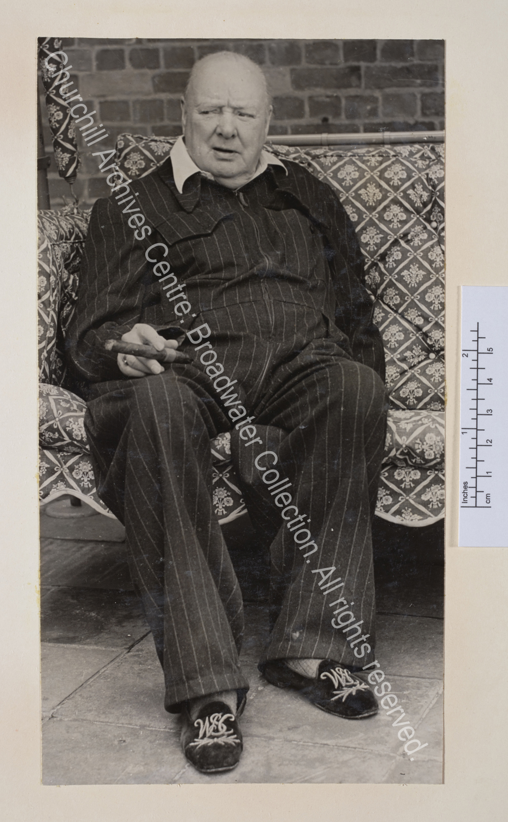 Photo of WSC wearing a pin-striped siren suit and monogrammed slippers