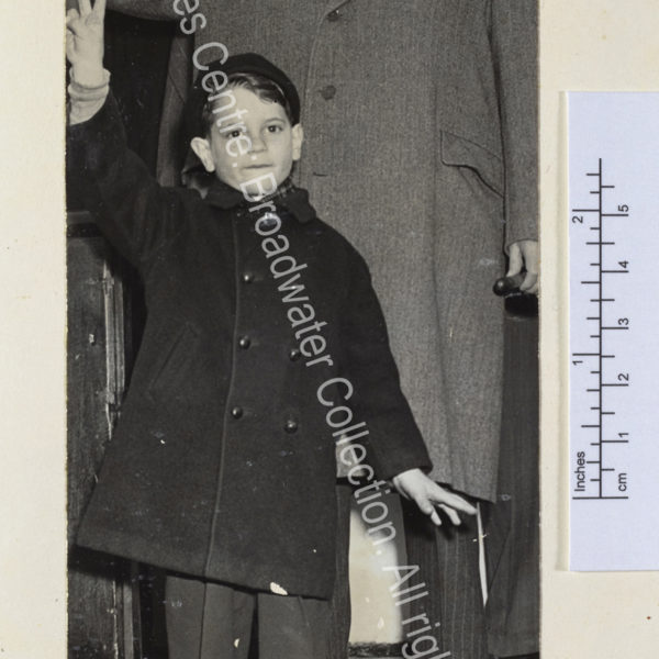 Photo shows WSC [returning from the United States on the Queen Mary] wearing a pale overcoat