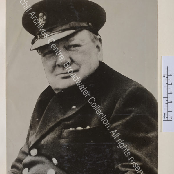 Head and shoulders photo of WSC wearing a peaked cap. Signed "Winston Churchill 1949".
