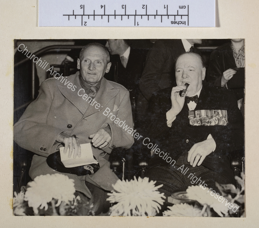 Photo of WSC and [1st Lord] Montgomery of Alamein seated side by side. WSC is wearing medals.
