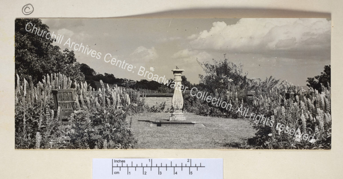 View of garden: a sundial in a walled garden with bench.
