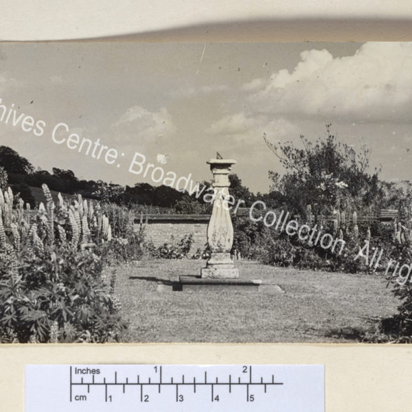 View of garden: a sundial in a walled garden with bench.
