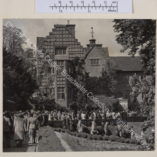 Exterior view of the south front at Chartwell with crowds of people queuing and walking in the grounds.