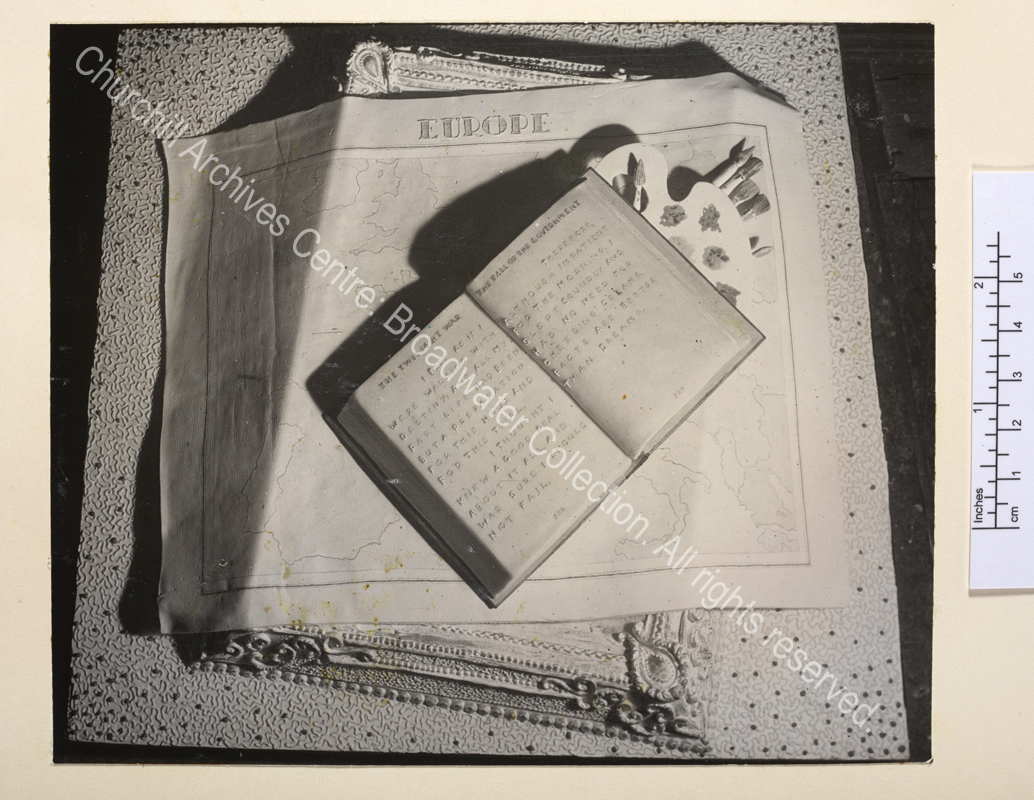 Birthday cake illustrating some of WSC's activities: an open copy of WSC's "The Second World War" is arranged on top of an easel and paintbrushes