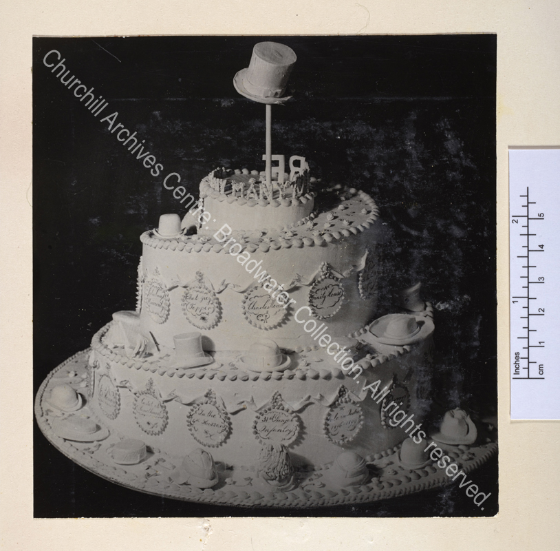 Three-tiered birthday cake decorated with different styles of hat worn by WSC.
