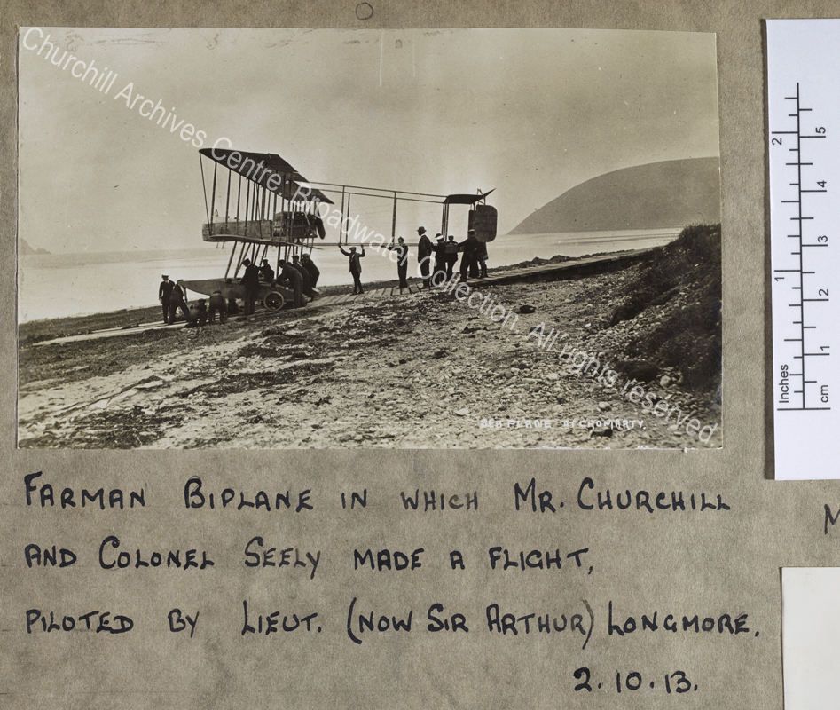Photograph of an aircraft being wheeled by a group of men on a wooden ramp leading down to the sea.  An original caption in white on the photograph says "Sea plane at Cromarty" [Cromarty Naval Air Station
