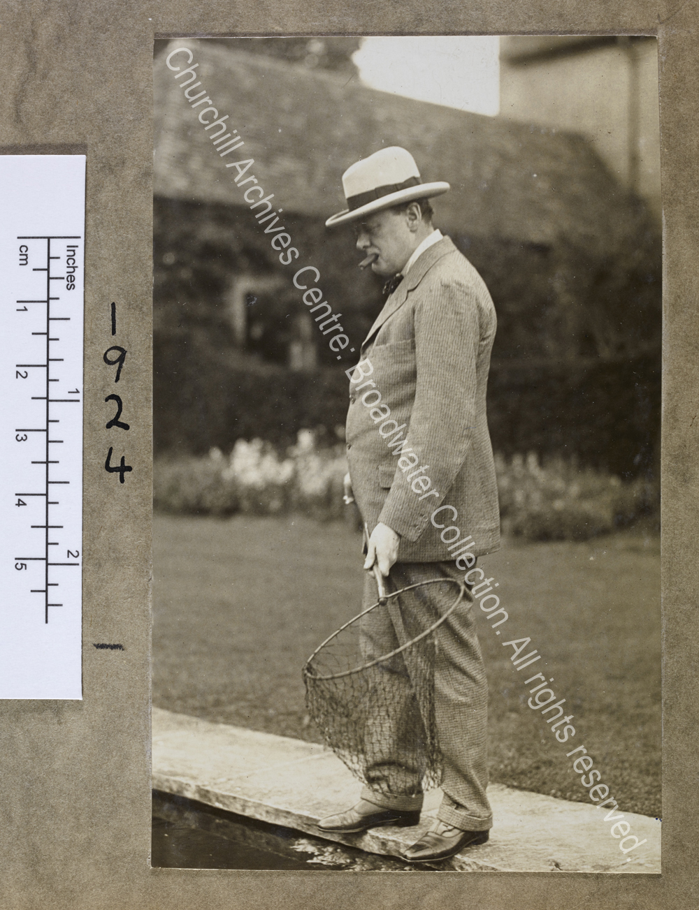 Photograph of WSC standing on the edge of the fishpond at Chartwell [Kent]