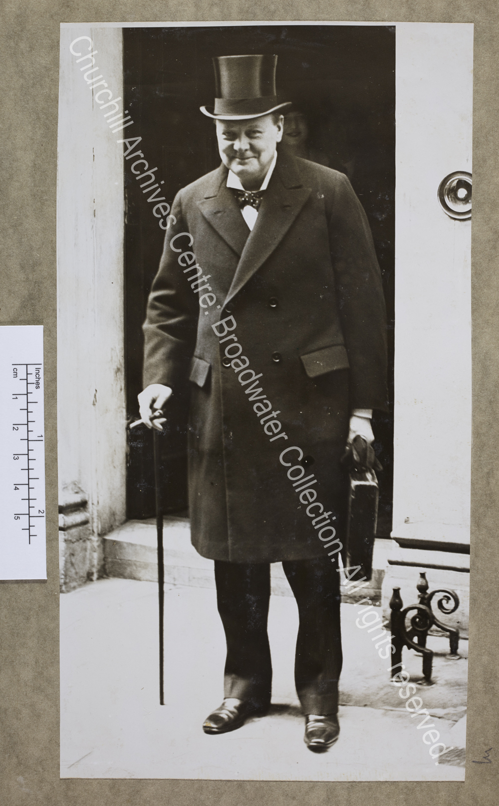 Full length photograph of WSC standing just outside the doorway of 11 Downing Street