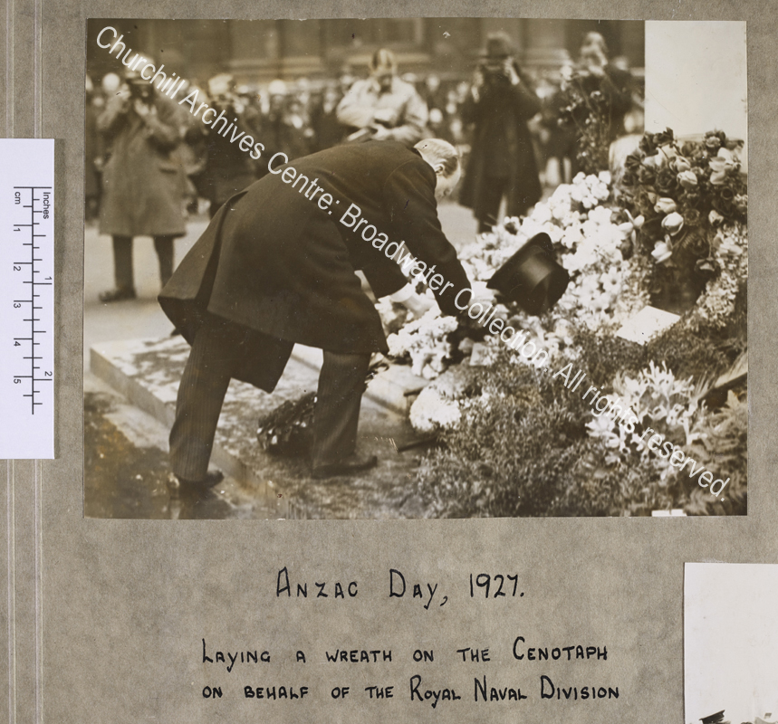 Photograph of WSC [Chancellor of the Exchequer] bending down at the foot of the Cenotaph [London] to lay a wreath.  He has his back mostly to the camera