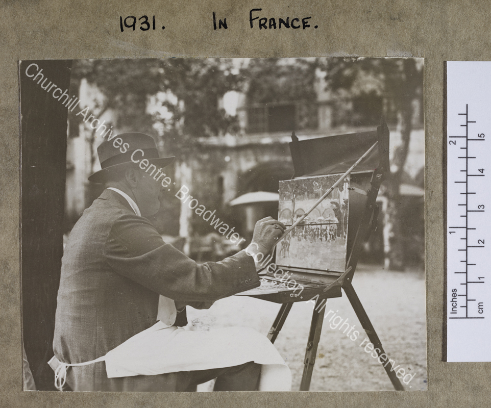 Three quarter length photograph of WSC painting [at St Jean de Luz].  He is sitting under a tree