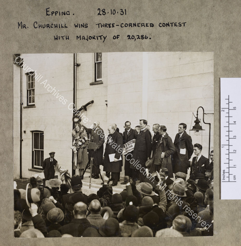 Photograph of WSC and a group of others (including CSC) on an outside platform in front of a crowd of people in Epping [Essex]