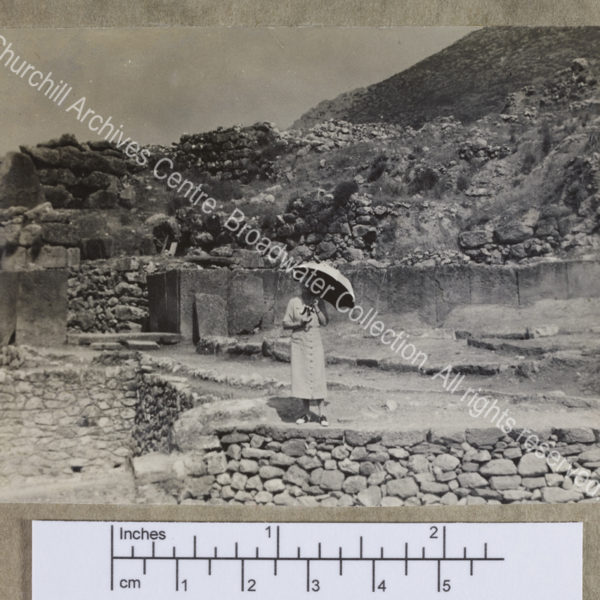 Photograph of CSC [while on a cruise of the Eastern Mediterranean on 1st Lord Moyne's yacht the Rosaura].  She is standing in the middle distance amid the walls of a ruined [?] classical site