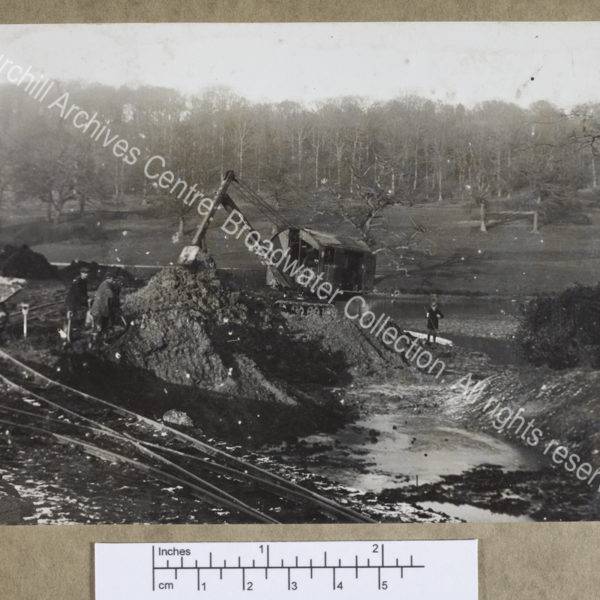 Photograph of a mechanical excavator and workmen digging in the drained lower lake at Chartwell [Kent]